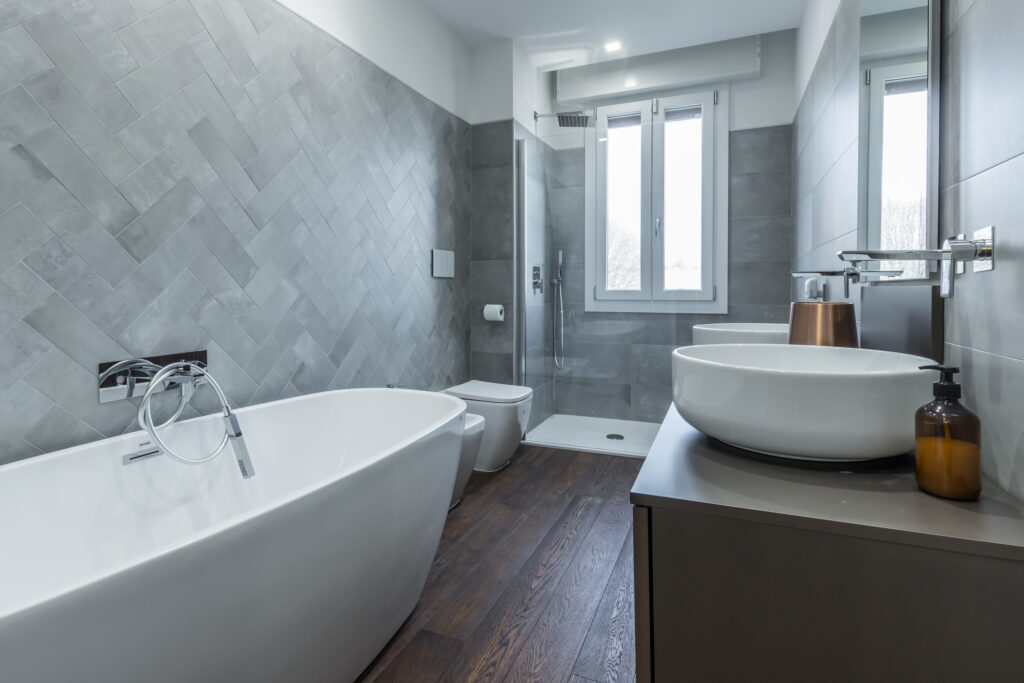 Bagno di design a Parma con vasca freestanding e doccia.